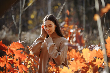 portrait of a woman against the background of an autumn forest on a sunny day