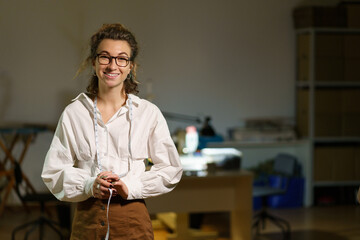Happy smiling tailor. Portrait of young self-employed woman sewing business owner. Confident...