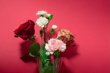 Big red rose with white carnations bouquet close up. Red background interior. Florist shop display with copy space.	Valentine day flowers gift.
