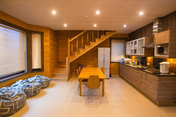 Living room interior. Country house kitchen interior. Kitchen is combined with dining room. Interior is made of light wood. Concept - renting a country house. Living room of country house.