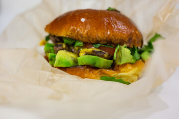 Vegan burger close up with avocado and cheese. Ketogenic food. Cheeseburger healthy fast food.