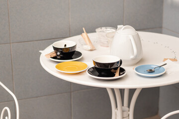 White table with tea and coffee cups  serving. Restaurant outdoors furniture and beverage.