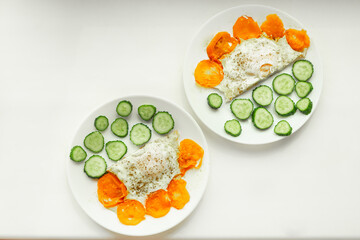 Soft focus,  breakfast plates for two. Selective focus. Sliced cucumber, fried scrambled eggs close up.