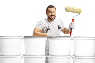 House painter standing behind a pile of buckets and holding a paint roller
