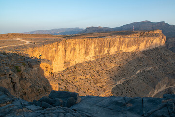 Fototapeta na wymiar Spectacular Cliffside View of Jebel Shams. Sunlight illuminates the towering cliffs of Jebel Shams.