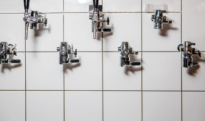 Taps in the wall for pouring beer into plastic dishes.