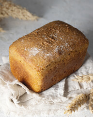 Whole grain loaf bread and spikelets of rye on white background isolated