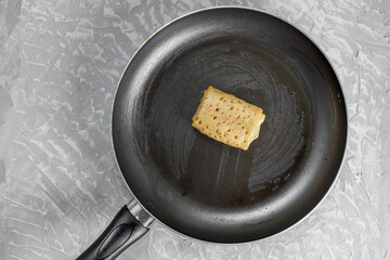 The stuffed pancake lies in a frying pan, with a non-stick coating, greased with oil.