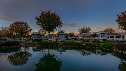 Reflection in the pond of the campers parked next to it in the early morning sunrise