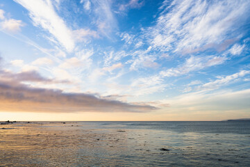 Sunset over the sea with cloudy blue sky in Algarrobo, Chile. Splendid twilight with sun reflection on ocean