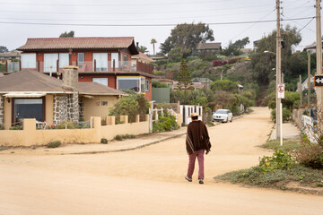 Fototapeta na wymiar Lonely peasant man walking on empty unpaved street during Covid-19 pandemic in Algarrobo, Chile