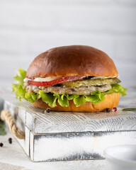 Close up of homemade fresh burger with meat,lettuce,tomato,cheese isolated on wooden serving box 