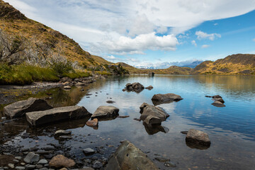 Serene landscape of rocks in the lake surrounded by mountains,Torres del Paine National Park, Chile