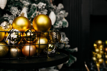 Christmas tree in the interior of the living room of a residential building in black and gold colors. festive atmosphere before Christmas. holiday card