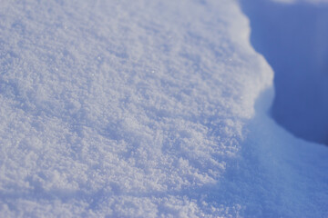 Fototapeta na wymiar white shining snow with blue wavy shadow in winter