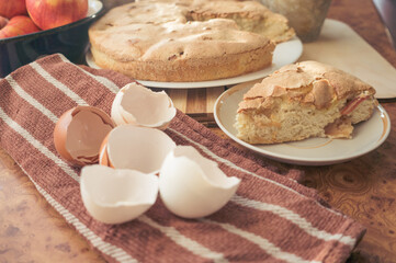 Homemade and puffed apple biscuit and sliced ​​pie in a saucer on the table.