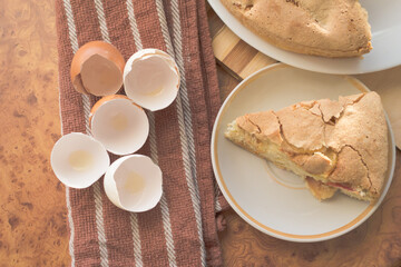 Homemade and puffed apple biscuit and sliced ​​pie in a saucer on the table.