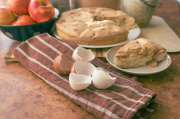 Homemade and puffed apple biscuit and sliced ​​pie in a saucer on the table.