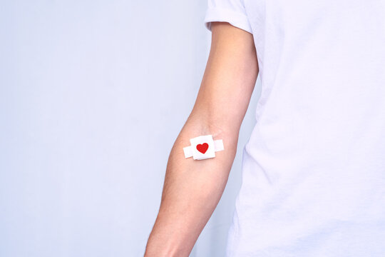 Blood donation. Blood donor with bandage after giving blood on a white background. Copy space