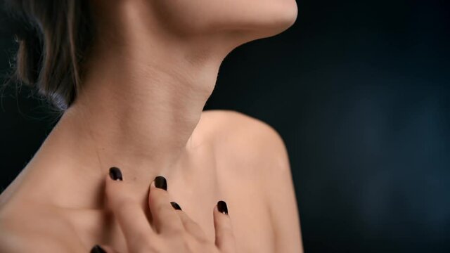Brunette fashion female model stroking tender softness neck face skin plastic surgery isolated black