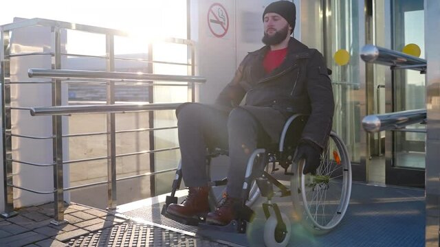 Man in wheelchair got over city stairs with elevator for disabled people