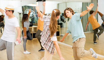 Group of teenagers performing strange dance together in studio.