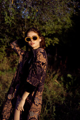 pretty woman in fashionable clothes sunglasses nature posing