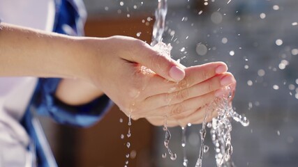 a man with white skin washes his hands with water close-up in the summer, skin hygiene and...