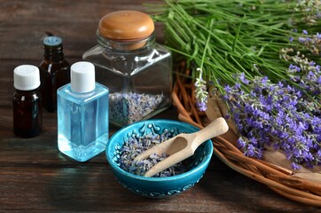 Fresh and dry lavender flowers with bottles of essential oil and lavender water for spa procedures or natural cosmetics production. Aromatherapy and spa concept.