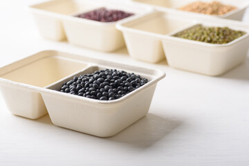 Black soybeans in compostable cardboard boxes are eco-friendly concepts and are mainly used as a plant-based ingredient in vegetarian, healthy food.