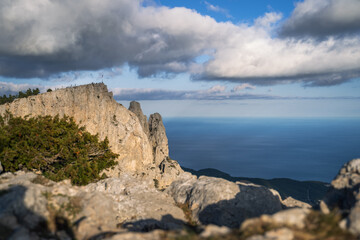 Fototapeta na wymiar High rocks Ai-Petri of Crimean mountains. Black sea coast and blue sky with clouds in autumn. Russia