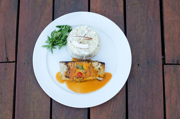 grilled salmon with sauce and rice and herbs