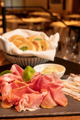 Tigelle with culatello and lardo, served with fresh baked biscuits.