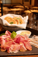 Tigelle with culatello and lardo, served with fresh baked biscuits.