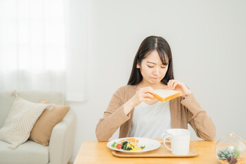 Obraz na płótnie Canvas 食パンを食べる女性（食欲不信・食べれない） 