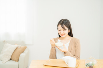 Fototapeta na wymiar ヨーグルトを食べる女性 