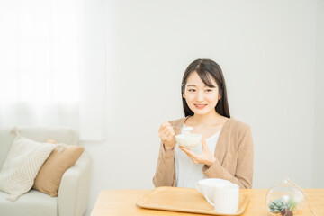 Obraz na płótnie Canvas ヨーグルトを食べる女性 
