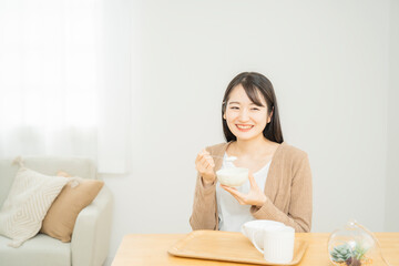 Obraz na płótnie Canvas ヨーグルトを食べる女性 