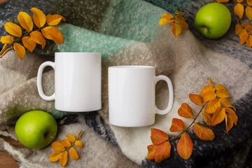 Two white coffee mug mockup with White coffee mug mockup with woolen scarf, apples and fall leaves