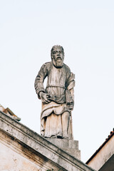 Fototapeta na wymiar Sculpture of a man with a book on the Church of Saint apostle Mark. Montenegro