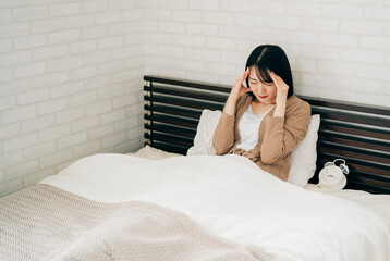 ベッドルームにいる女性（頭痛・泣く）
