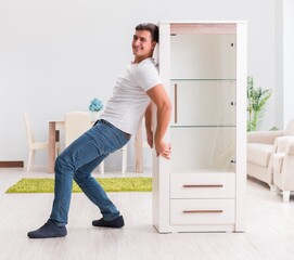 Man moving furniture at home