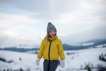 Cute little girl on snow winter nature. Funny kid in winter clothes. Children play outdoors in snow. Kids Christmas vacation.