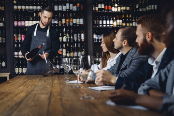 Sommelier pouring red wine into carafe decanter to make aeration drink. Concept for training bartenders and waiters