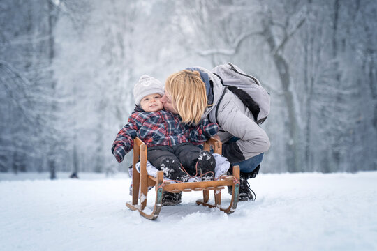 Matka z dzieckiem na sankach 