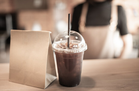 barista serving coffee frappe in plastic cup - Powered by Adobe