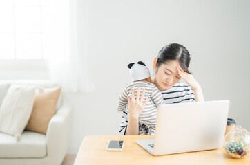 赤ちゃんの世話をしながら電話する女性（困る）
