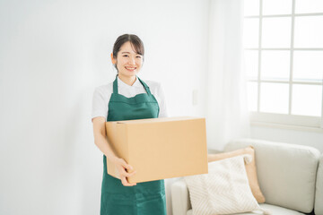 ダンボールを運ぶ女性
