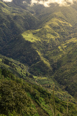 Naklejka premium vertical shot of a green hill surrounded by tropical forest and coffee plantations with a small river in Perez Zeledón in Costa Rica