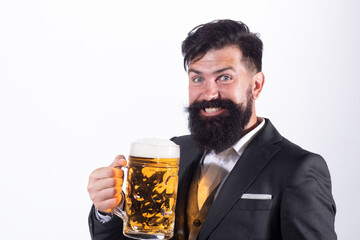 Happy man in classic suit drinking beer. Bearded guy in business outfit looks happy and satisfied. Portrait of man with lifted high glass of beer isoalted on white.